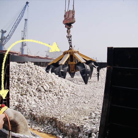 Diesel hydraulic orange peel grab is remote controlled and grabs light coarse stones. The picture shows a hand holding the remote control and a yellow arrow illustrates the controls