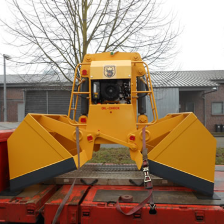 Diesel-hydraulic clamshell bucket, remote-controlled, biomass type: DHZ, secured on a red loading platform for transportation