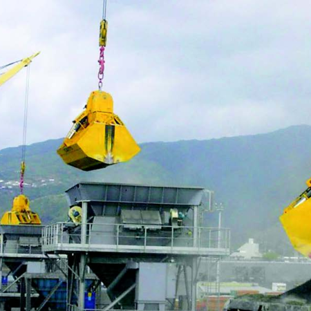 Three diesel-hydraulic clamshell buckets type DHS-B load material at the port